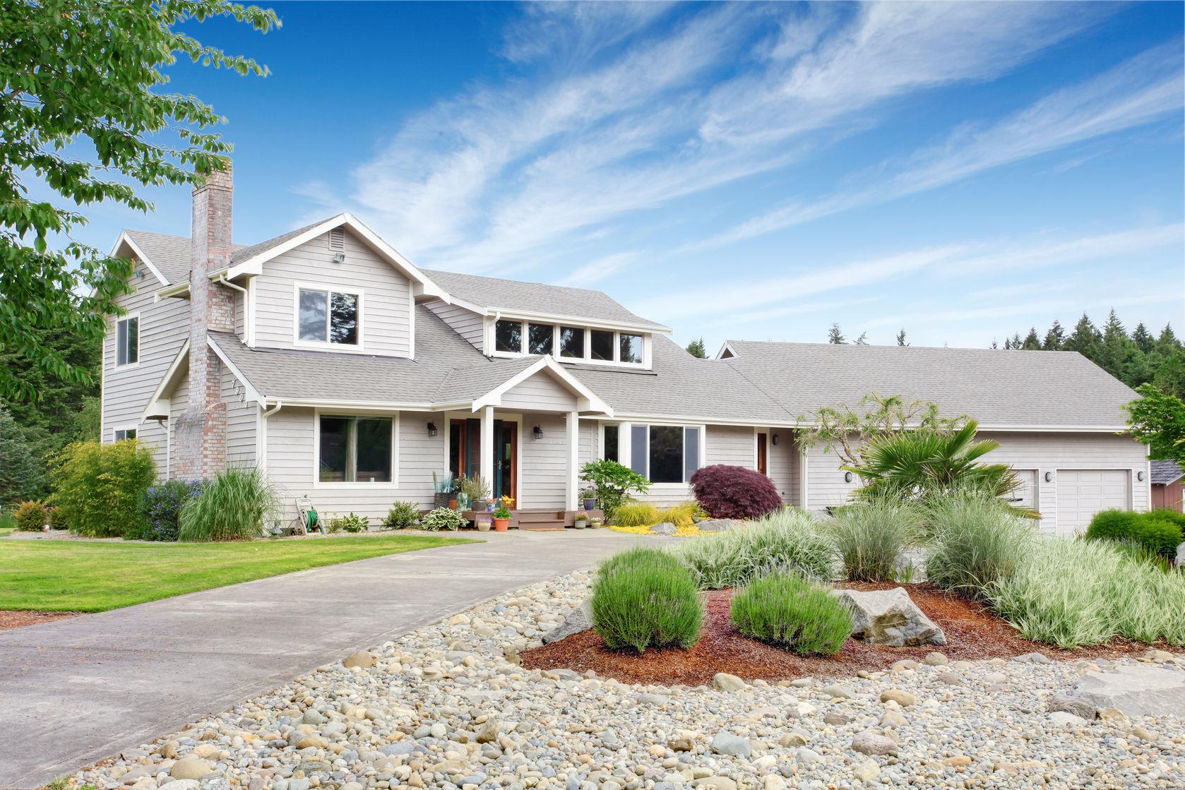 59955641 - large beige house with white trim, and well kept lawn, along with three garage spaces and landscaping desing