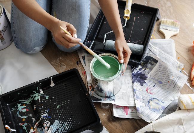 Woman painting her house.