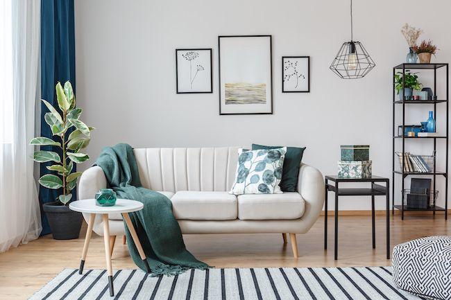 Living room staged with white couch and green accents.