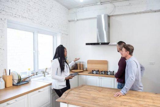 woman showing couple around house